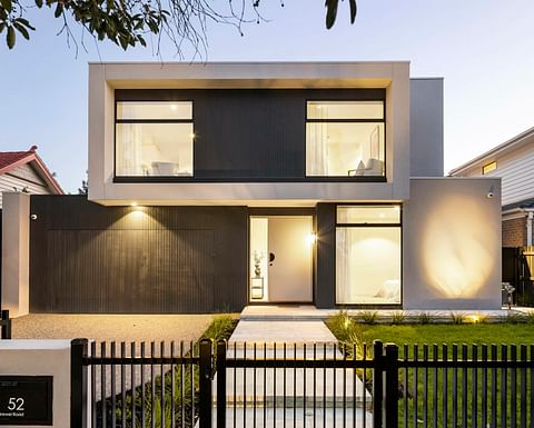 Modern architecture façade with wide second story, glass windows and rendered exterior