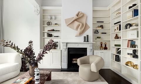 Living room interior with built-in shelving and a marble fireplace